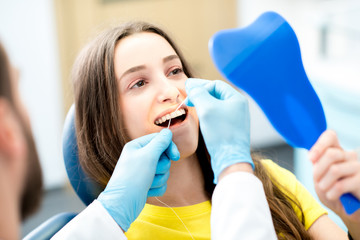 Professional teeth cleaning with dental floss at the dental office