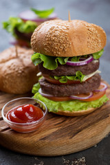 Close-up of double burger with beef meat and vegetables, selective focus, shallow depth of field