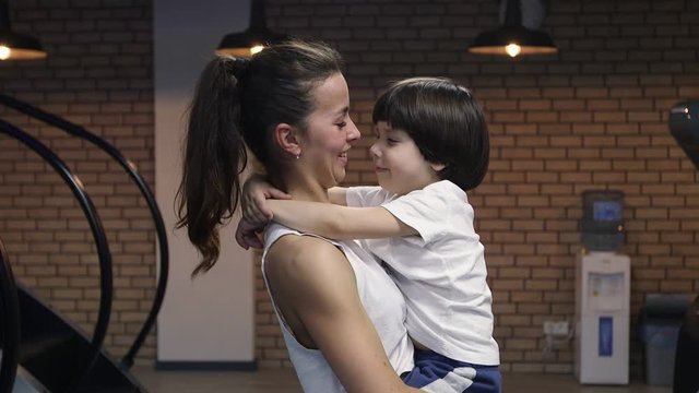 Mother and son posing on camera at gym