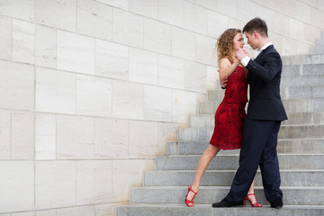 man and woman dancing tango on street staircase - obrazy, fototapety, plakaty