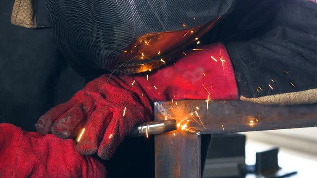 Welder. Worker operating welding machine, welding metal 4K