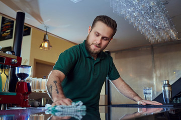 Barista bartender washes the surface of  bar. Cleaning in a cafe restaurant.