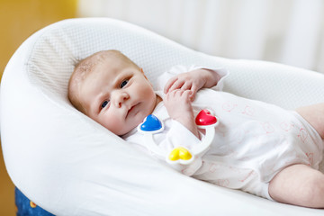 Cute baby girl playing with colorful rattle toy