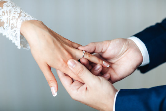 The hands of the newlyweds. A man's hand puts on a ring. wedding ceremony. Bride hands