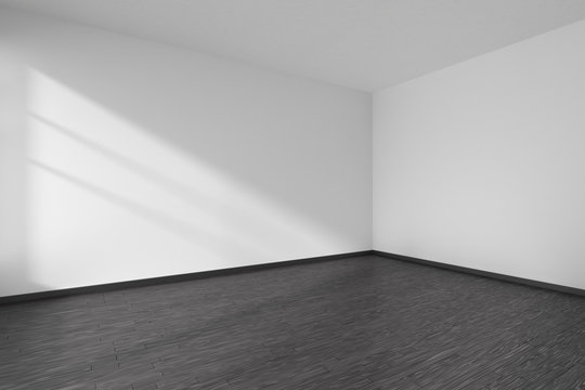 Corner of empty room with black parquet floor and white walls