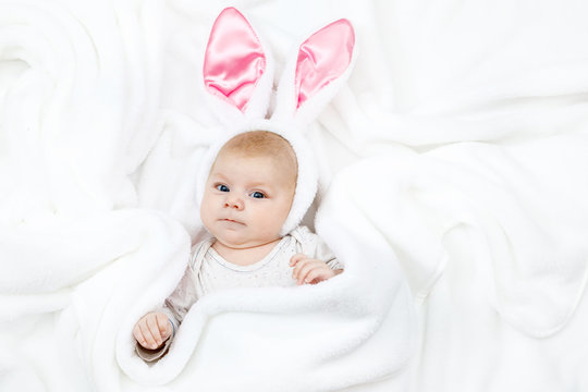 Adorable cute newborn baby girl in Easter bunny costume and ears.