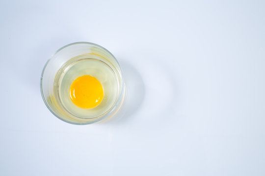 Raw chicken egg in glass bowl isolated on white background