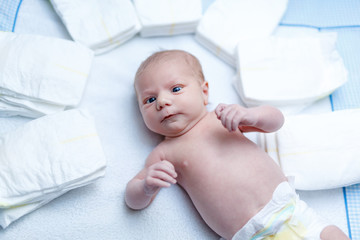 newborn baby on changing table with diapers