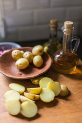 Sliced raw potato on wooden cutting board on vintage background