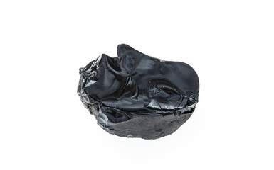 Bitumen, a piece of black resin on a white background