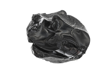 Bitumen, a piece of black resin on a white background