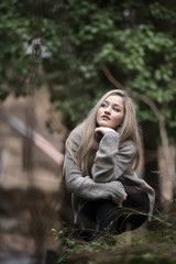 Cute blond teen with nice figures at the forest wear polo neck and black pants