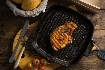 A piece of meat on the grill on wooden table