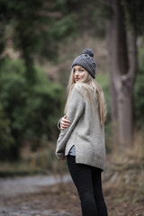 Cute blond teen with nice figures at the forest wear polo neck and skull cap