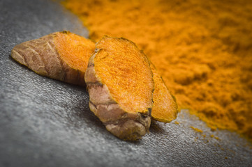 dust of ground turmeric on the grey background