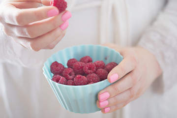 Woman holding raspberries in hands 