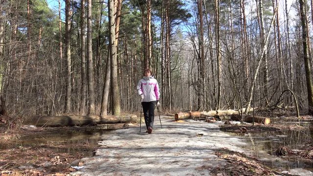 Nordic walker girl in spring forest.