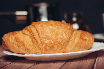 Croissant in a plate on a wooden table