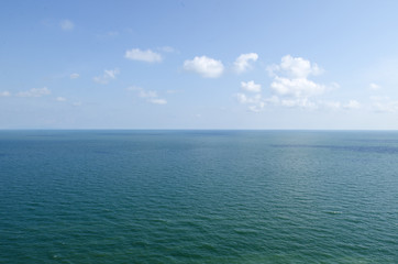 Blue sea and sky with white clouds.