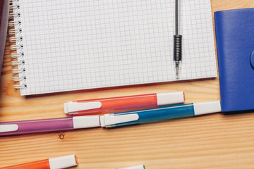 Notebook in the cage and markers on the table