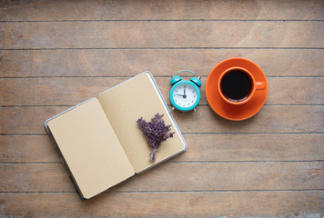 Obraz na płótnie Canvas photo of opened notebook, bunch of lavender, alarm clock and cup of coffee on the wonderful wooden brown background