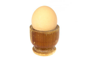 Boiled egg in wooden egg cup isolated on white
