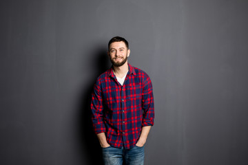 Happy young man. Portrait of handsome young man in casual shirt with hands in pockets and smiling