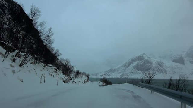 Fahrt auf der E10 bei Schneesturm, Norwegen
