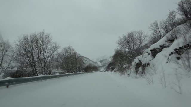 Fahrt auf der E10 bei Schneesturm, Norwegen
