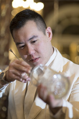 Chinese Barman is making cocktail at night club.