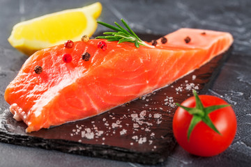 trout with lemon  and tomato on black stone