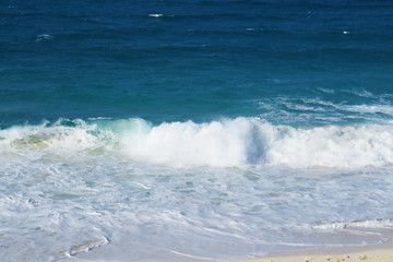 Naklejka premium A small ocean wave on the beach during a bright sunny day. New Providence, Nassau, Bahamas.