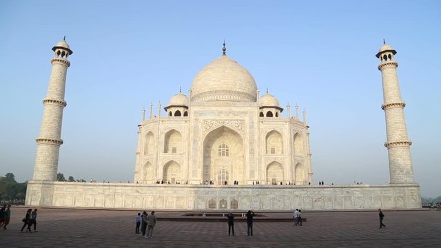 AGRA, INDIA - 26 FEBRUARY 2015: Taj Mahal front view, with tourists walking in garden.