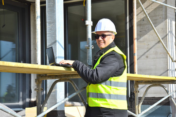 Bauleiter mit Laptop auf der Baustelle