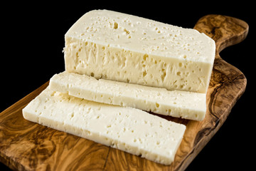 Slices of traditional sfella cheese of Peloponnese, Greece, on wooden chopping board