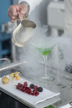  barman is making Fruit cocktail with dry ice
