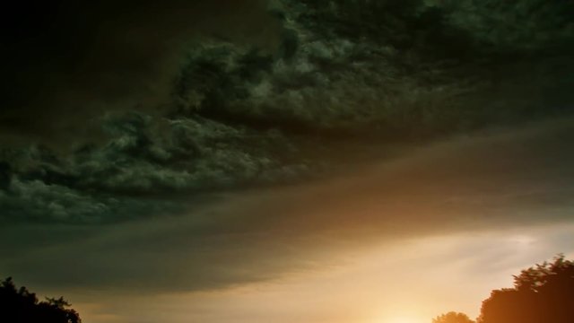 extreme thunderstorm with massive clouds in cloudscape and backlight sun