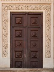 Crafty wooden door on decorated stucco wall