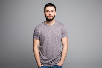 Handsome young man,boy,posing in grey shirt and jeans with hands in pockets