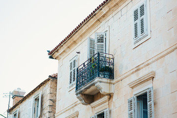 Fototapeta na wymiar Forged balcony in an old house. Balkan architecture, Montenegro, Croatia