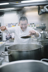 Fototapeta na wymiar Chinese cook preparing stew in the pan