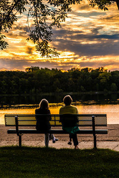 Family And Friends Are Having Fun Under Sunset Over A Lake