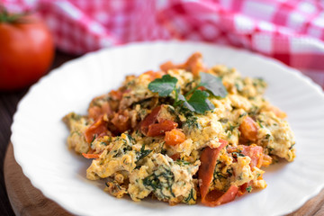 Fried eggs with tomato on dark wooden table