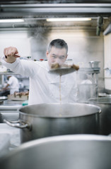 Fototapeta na wymiar Chinese cook preparing stew in the pan
