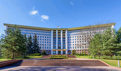 Parliament of the republic of moldova in chisinau, national flag, stefan cel mare street, spring time with blue sky