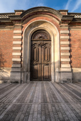 Fantasy wooden door in brick arc Epernay, Avenue de Champagne, France