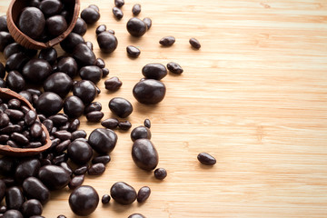 Chocolate easter eggs, brown sweets candy on a textured wooden background. The concept of a holiday and a happy Easter. With space for text