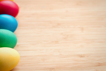 Multicolored easter eggs, on a textured wooden background. The concept of a holiday and a happy Easter. with space for text