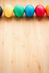 Multicolored easter eggs, on a textured wooden background. The concept of a holiday and a happy Easter. with space for text