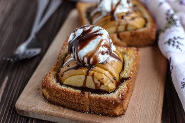 Baked apples with toast and ice cream on a rustic background